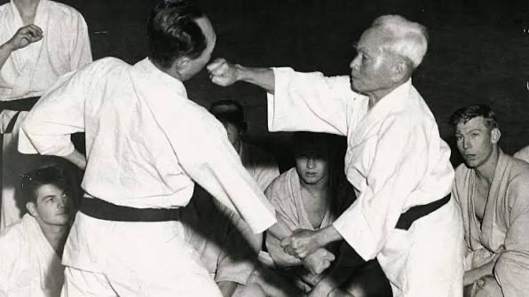 Gichin Funakoshi demonstrating the use of Nakadaka Ken (Middle Knuckle Strike) on Isao Obata.